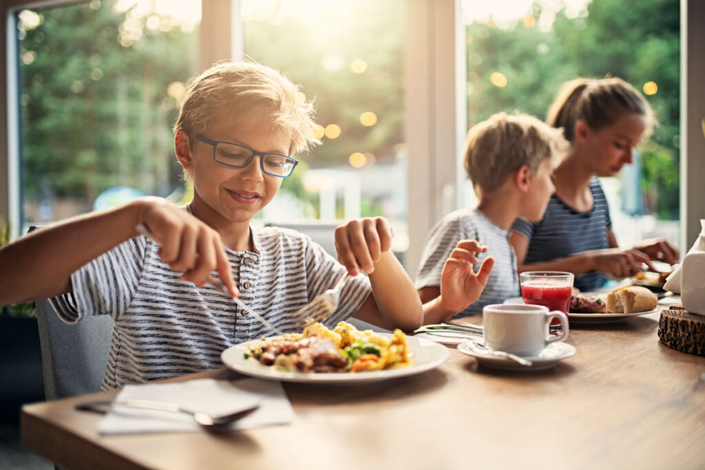Glückliche Kinder sitzen an einem Esstisch