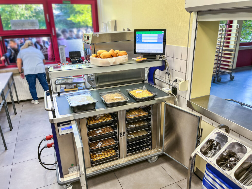 Buffetwagen Temp Classic Pro mit Steuerdisplay und vorbereiteten Speisen in einer Schulküche